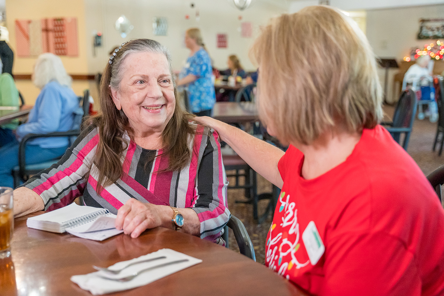 A staff memeber spending time with a resident while they eat