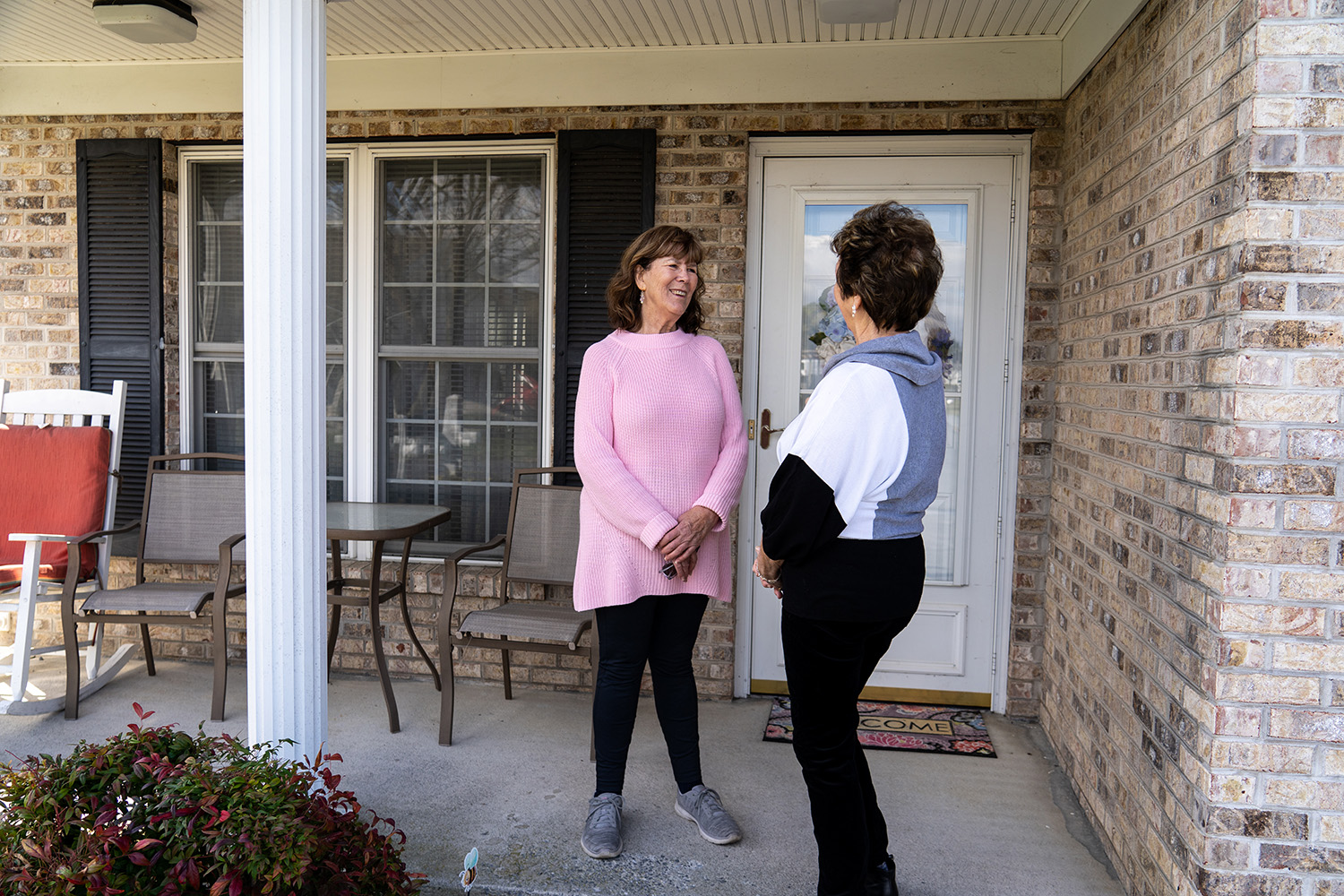 Two residents chatting infront of one of their homes