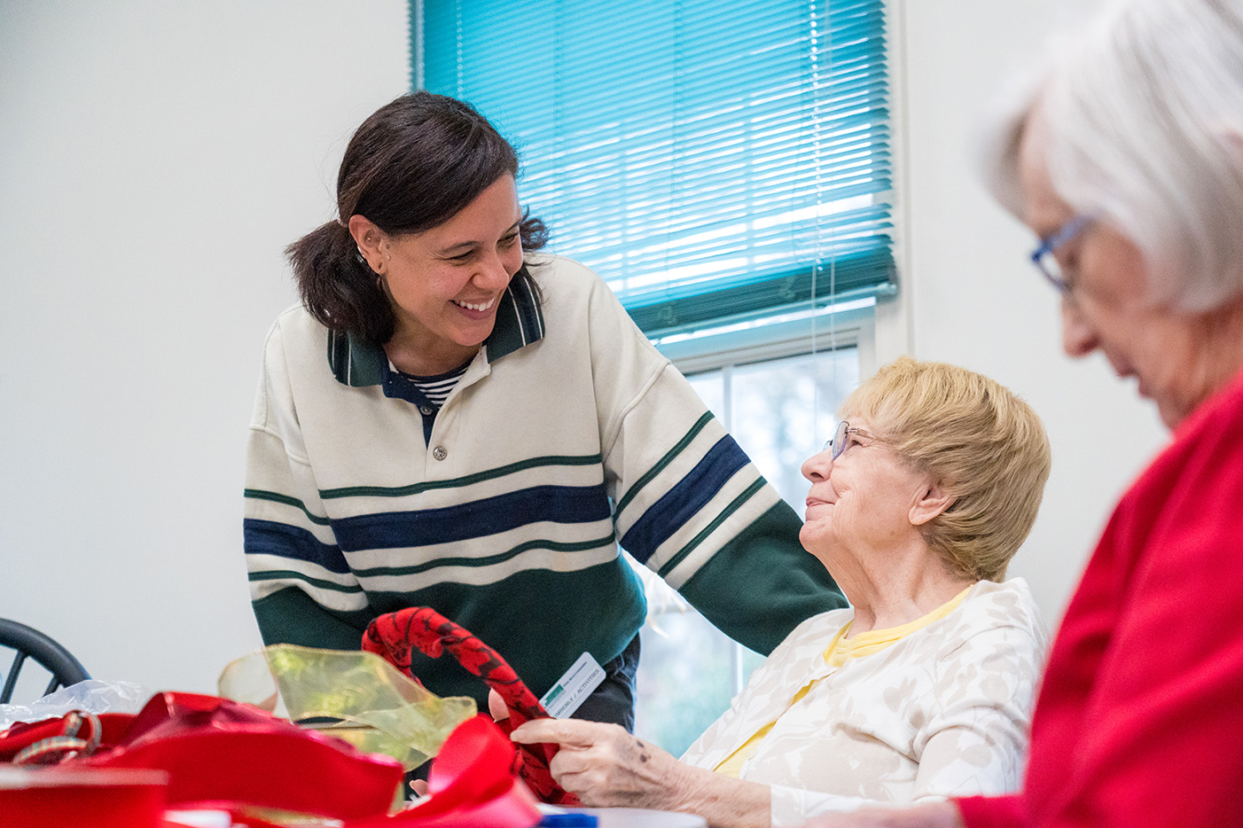 A women interacting with a senior resident during and arts and crafts event